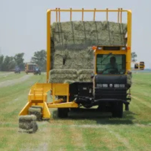 A tractor bailing hay.