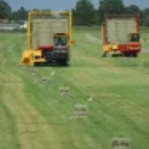 Tractors bailing hay.